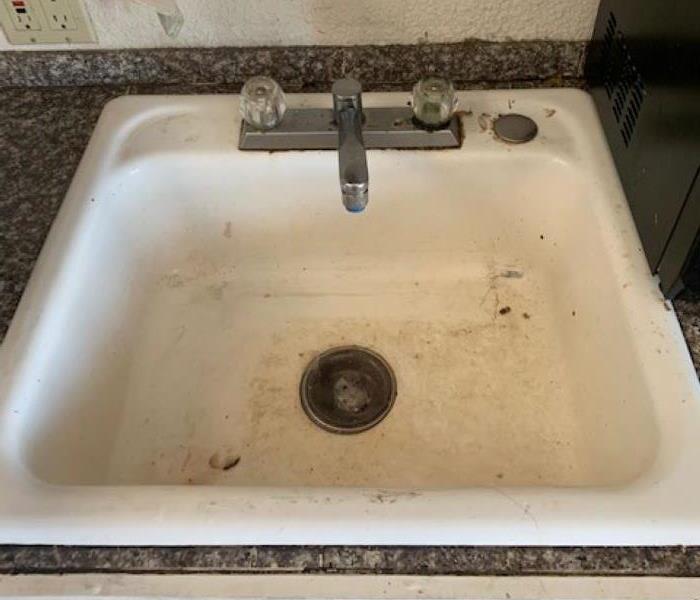 white sink with dirt in it