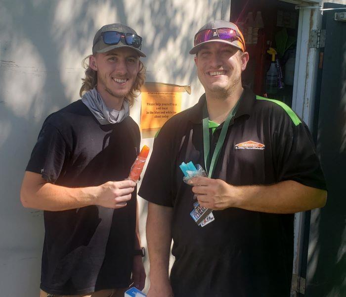 Photo shows two SERVPRO employees eating popsicles