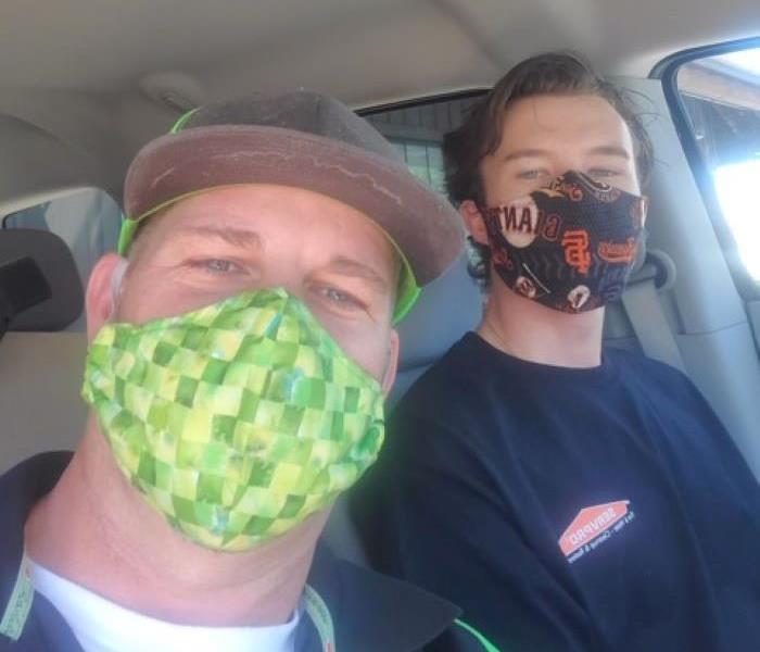 Picture shows two of our employees with their masks on in the car