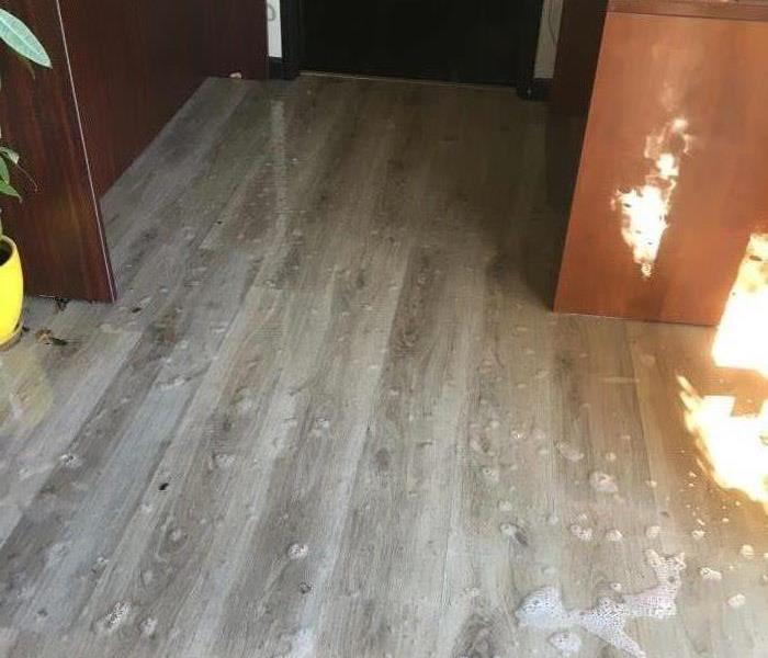 This picture shows a lot of water on the floor of the reception area of SERVPRO's offices.
